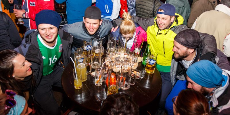 Jongeren genieten samen van après-ski tijdens wintersportvakantie in Oostenrijk