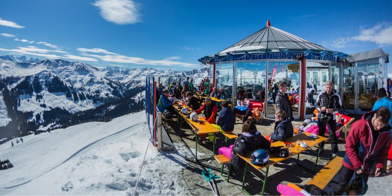 Skiërs en snowboarders ontspannen op bergterras met panoramisch uitzicht in Oostenrijk